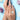 Hand wearing a pearl ring with flowers on a light blue background