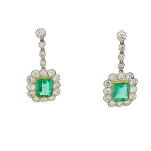 Pair of emerald and diamond earrings on a white background