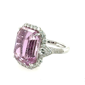 Ring with a kunzite gemstone and diamond-studded band on a white background