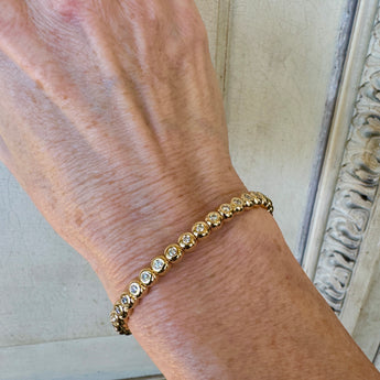 Diamond bracelet worn on wrist – elegant stackable yellow gold jewelry from HGM Jewelry in New Orleans