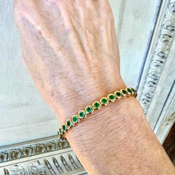 Emerald bracelet worn on wrist – handcrafted 18k yellow gold jewelry from New Orleans