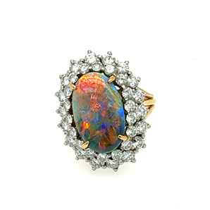 Estate black opal ring in 18K yellow and white gold with 2.50 carats of diamonds, front view showcasing vivid opal play-of-color.