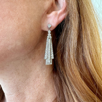 Model wearing platinum Art Deco diamond drop earrings – handcrafted fine jewelry from HGM Jewelry New Orleans
