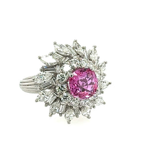 Angled view of a platinum pink sapphire and diamond ring, showcasing the layered diamond halo and vibrant center gem.