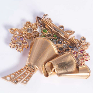 Side view of vintage flower brooch with blue sapphires, rubies, emeralds, and diamonds in 18k yellow gold
